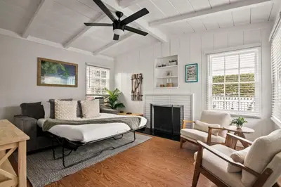 a living room with a bed and a fireplace at Beautiful Windansea Beach Compound Steps to Sand in San Diego