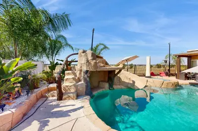 a pool with a water slide in a resort at Outdoor Oasis with Pool and Hot Tub Perris Getaway in Perris