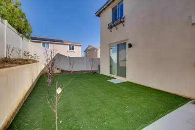 a small backyard with a green lawn at 1 Mi to Heritage Lake Park Duplex with Patio! in Menifee
