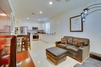 a living room with a couch and a kitchen at 1 Mi to Heritage Lake Park Duplex with Patio! in Menifee