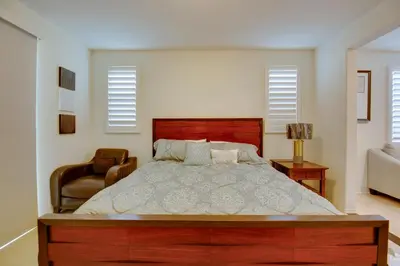 a bedroom with a large bed and a chair at 1 Mi to Heritage Lake Park Duplex with Patio! in Menifee