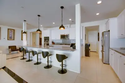a kitchen with a large counter and stools in the middle at Luxurious and Spacious Family Duplex in Menifee! in Menifee