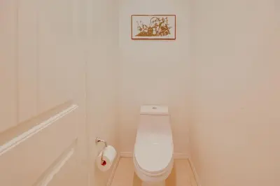 a bathroom with a toilet with a picture on the wall at Luxurious and Spacious Family Duplex in Menifee! in Menifee