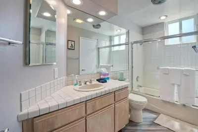a bathroom with a sink and a toilet and a mirror at 901 S Pacific in Oceanside