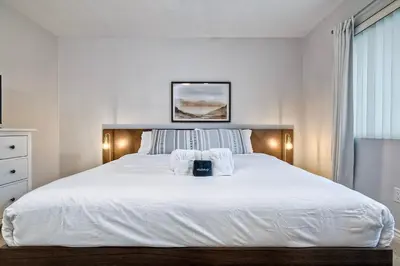 a bedroom with a large white bed with towels on it at 3080 Lincoln - Unit 12 in Carlsbad