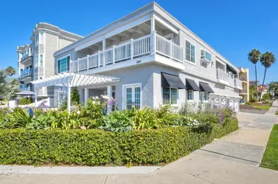 a white house with a balcony and plants at 3690 Carlsbad Boulevard - Unit C in Carlsbad