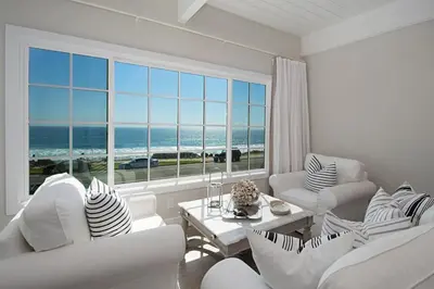 a living room with white furniture and a large window at 3690 Carlsbad Boulevard - Unit B in Carlsbad