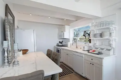 a kitchen with white cabinets and a white refrigerator at 3690 Carlsbad Boulevard - Unit B in Carlsbad