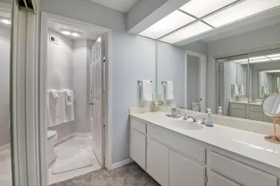 a white bathroom with a sink and a mirror at 400 N Pacific - Unit 203 in Oceanside