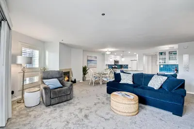 a living room with a blue couch and a chair at 400 N Pacific - Unit 203 in Oceanside
