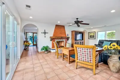 a living room with a table and a fireplace at 5100 El Arbol in Carlsbad