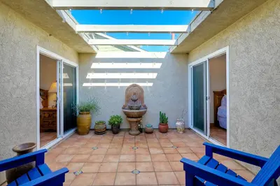 a patio with two blue chairs and a fountain at 5100 El Arbol in Carlsbad