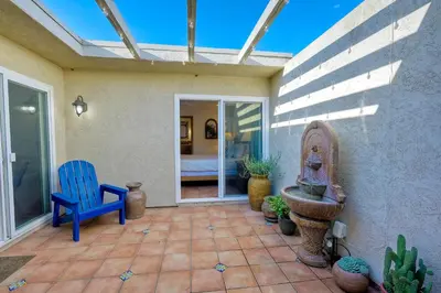 a patio with a blue chair and a fountain at 5100 El Arbol in Carlsbad