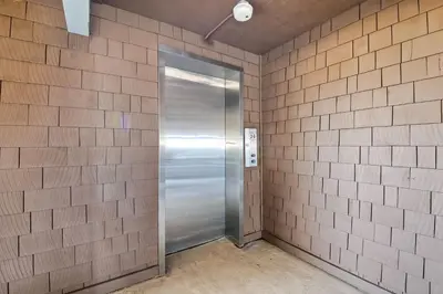 a metal elevator in a brick wall at 1445 S Pacific Street Unit E in Oceanside