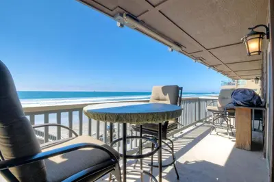 a balcony with a table and chairs and the ocean at 1445 S Pacific Street Unit E in Oceanside