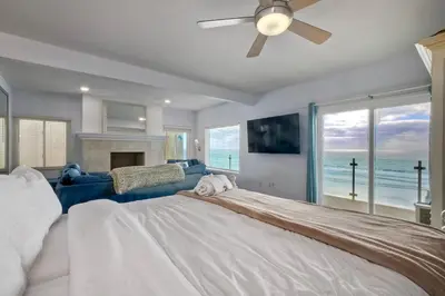 a large bedroom with a large bed and a fireplace at 1409 S Pacific Street 5BR in Oceanside