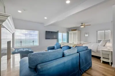 a living room with a blue couch and a bed at 1409 S Pacific Street 5BR in Oceanside