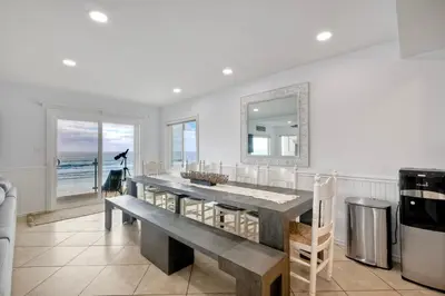 a dining room with a table and a mirror at 1409 S Pacific Street 5BR in Oceanside