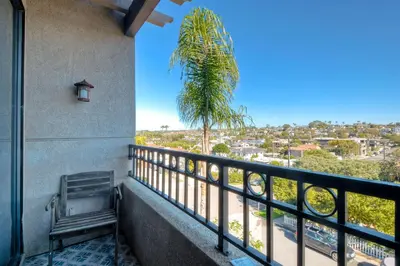 a balcony with a bench and a palm tree at 916 Sea Lane in Encinitas