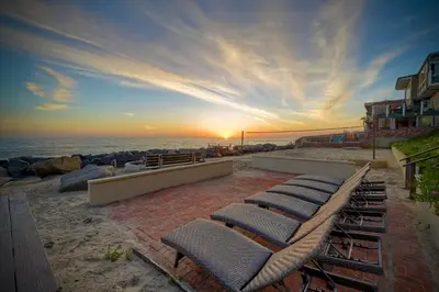 a group of lounge chairs on the beach at sunset at 1923 S Pacific in Oceanside