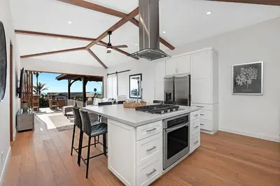 a kitchen with white cabinets and a table with chairs at 5194 Carlsbad - Upper in Carlsbad