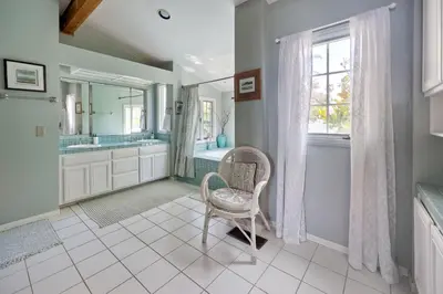a bathroom with a chair and a mirror at 5051 Shore Drive in Carlsbad