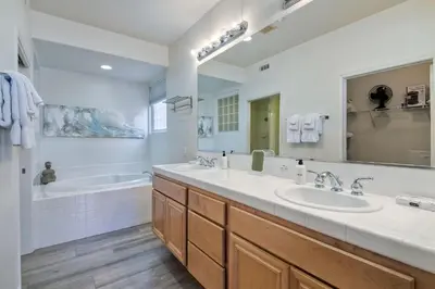 a bathroom with two sinks and a tub and a large mirror at 4025 Canario Street in Carlsbad