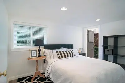 a white bedroom with a bed and a table at 180 Walnut Lower in Carlsbad