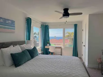 a bedroom with a bed and a window with a view at Oceanview Suite Hilltop in San Diego