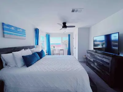 a bedroom with a large bed with a ceiling fan at Oceanview Suite Hilltop in San Diego