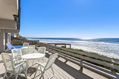 a patio with chairs and a table and the beach at 1317 S Pacific Unit B in Oceanside