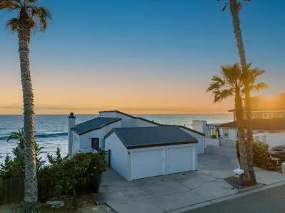 a house on the beach with palm trees and the ocean at 1317 S Pacific Unit B in Oceanside