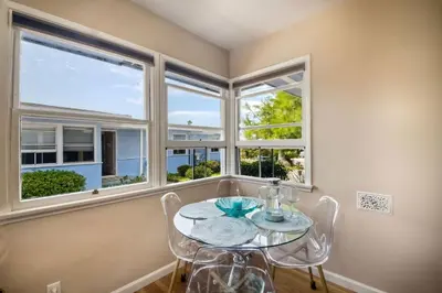 a dining room with a table and chairs and windows at 165 n 167 Tamarack in Carlsbad