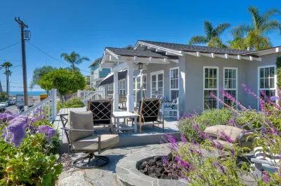 a house with chairs and flowers on a patio at 180 n 190 Walnut Entire Home in Carlsbad