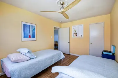 a bedroom with two beds and a ceiling fan at 165 Tamarack in Carlsbad