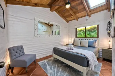 a bedroom with a bed and a chair and a mirror at 5194 Carlsbad Lower in Carlsbad