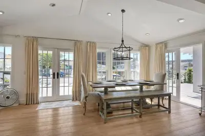 a dining room with a table and chairs and windows at 190 Walnut in Carlsbad