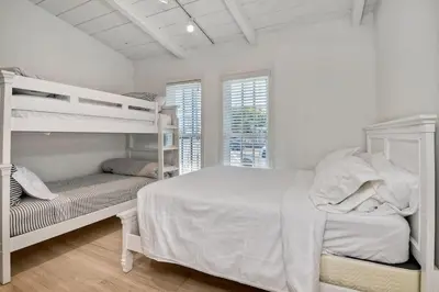 a white bedroom with two bunk beds and a window at 180 Walnut Upper in Carlsbad