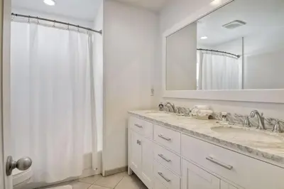 a white bathroom with a sink and a mirror at 180 Walnut Upper in Carlsbad