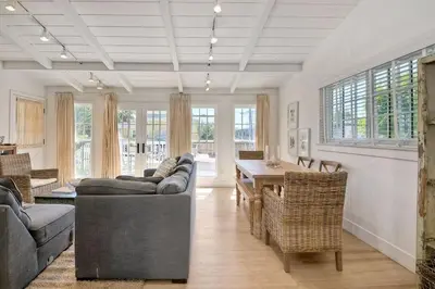 a living room with couches and a table and windows at 180 Walnut Upper in Carlsbad
