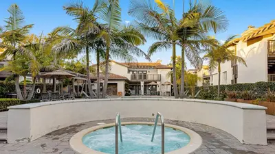 a swimming pool in a courtyard with palm trees at Walk to Beach Pool Hot Tub Private Patio Parking Seabreeze Retreat in Dana Point