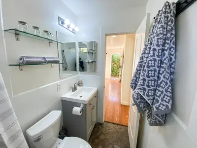 a bathroom with a toilet and a sink and a mirror at Hideaway in the heart of San Diego in San Diego