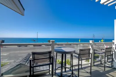 a table and chairs on a balcony overlooking the ocean at 3636 Carlsbad Blvd - Entire Home in Carlsbad