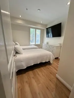 a white bedroom with a bed and a television at Irvine Gem Luxury condo 31 days min near Irvine Business & UCI Hospital in Irvine