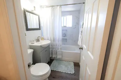 a white bathroom with a toilet and a sink at Family fun near the beach-sold in Oceanside