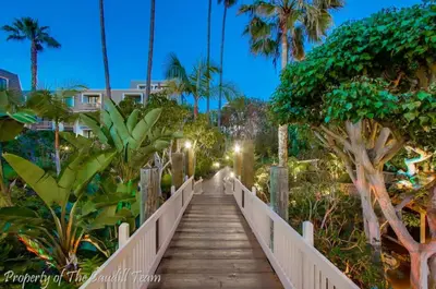 a wooden bridge leading to a beach with palm trees at Walk to the Beach Balcony Sunset Ocean Views in Oceanside