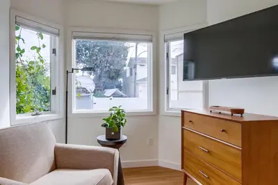 a living room with a tv and a chair and a dresser at Newly Renovated Pacific Beach Home with Private Yard and AC in San Diego