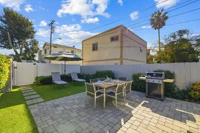 a patio with a table and chairs and an umbrella at Newly Renovated Pacific Beach Home with Private Yard and AC in San Diego