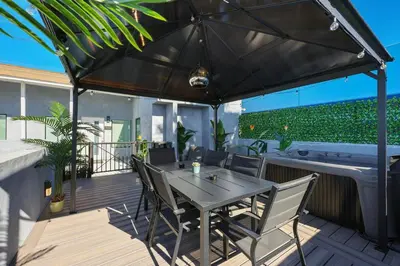 a table and chairs under an umbrella on a deck at Harborside Suite 06 with Hot Tub and King Beds in San Diego