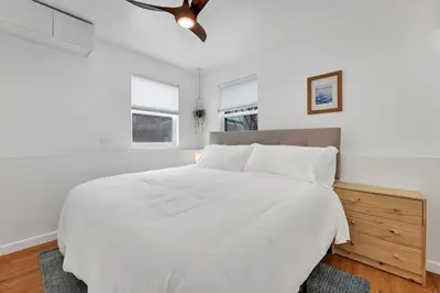 a white bedroom with a bed and a ceiling fan at Harborside Suite 06 with Hot Tub and King Beds in San Diego